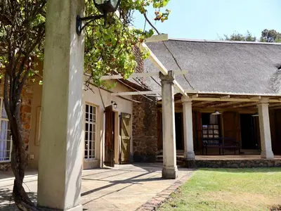 an outside view of a stone building with a porch at Winnaarspoort Lodge in Machadodorp