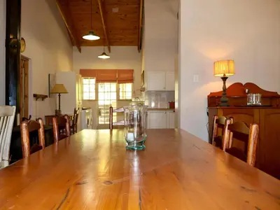 a dining room table with a glass vase on it at Winnaarspoort Lodge in Machadodorp