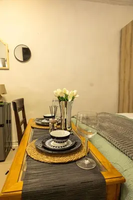 a table with a vase of flowers and wine glasses at Thorne's crip in Pretoria