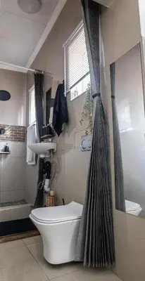 a bathroom with a toilet and a shower curtain at Thorne's crip in Pretoria