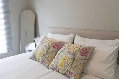 a white bed with two pillows on it at WiFi, Washer, Smart TV, Balcony & Pool in Midrand