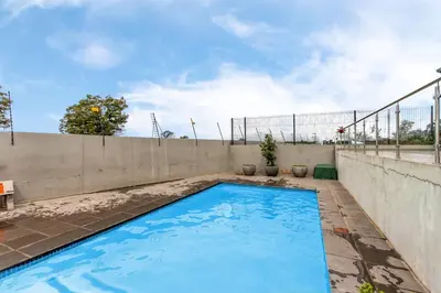 a swimming pool on the roof of a house at WiFi, Washer, Smart TV, Balcony & Pool in Midrand