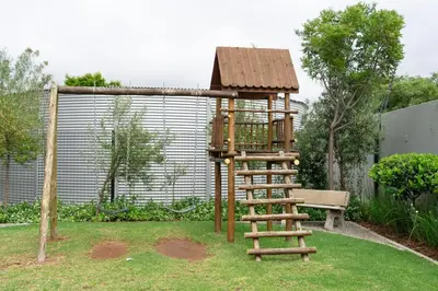 a wooden playground with a ladder and a bench at WiFi, Washer, Smart TV, Balcony & Pool in Midrand