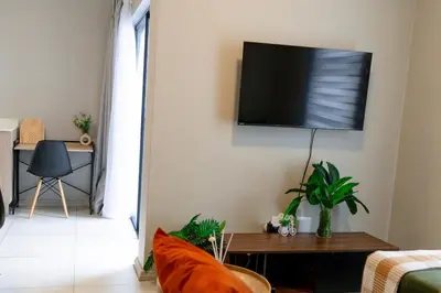 a living room with a flat screen tv on the wall at WiFi, Washer, Smart TV, Balcony & Pool in Midrand