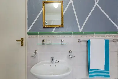 a bathroom with a sink and a mirror at Lodge At The Link in Kempton Park