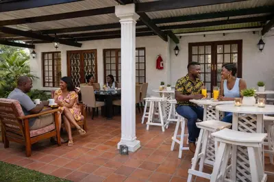a group of people sitting at tables in a restaurant at Lodge At The Link in Kempton Park