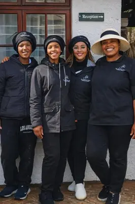 a group of four women standing next to a building at Lodge At The Link in Kempton Park