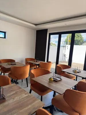 a restaurant with tables and chairs and a large window at The Spear Guest Lodge in Graskop