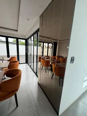 a restaurant with wooden chairs and tables and windows at The Spear Guest Lodge in Graskop