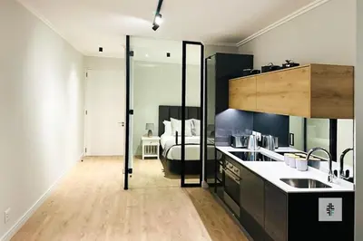 a kitchen with black cabinets and a bed in a room at Fezkho Boutique Stays in Midrand