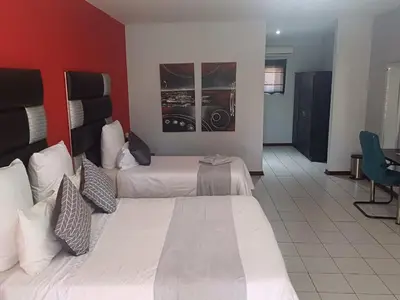a hotel room with two beds and a red wall at Africa Lodges in Thabazimbi