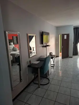a room with a mirror and a desk and a bed at Africa Lodges in Thabazimbi