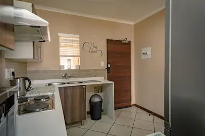 a kitchen with a sink and a counter top at Entire Modern Comfortable Lux Centurion Apartment in Pretoria