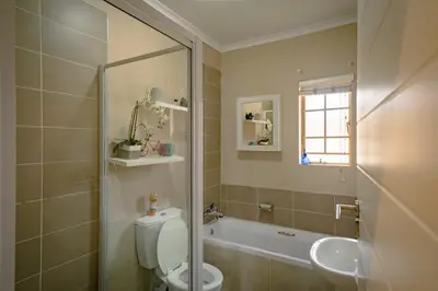 a bathroom with a toilet and a sink and a tub at Entire Modern Comfortable Lux Centurion Apartment in Pretoria