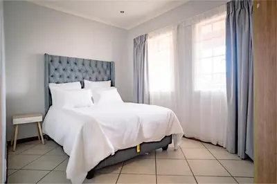 a bedroom with a large bed and a window at Entire Modern Comfortable Lux Centurion Apartment in Pretoria