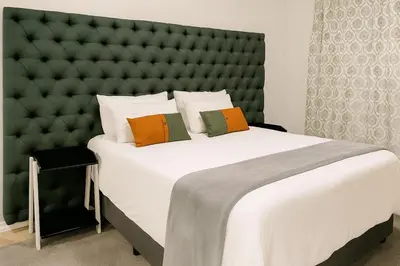 a bedroom with a large bed with a large headboard at Stylish 1 Bed Self Catering Near OR Tambo in Kempton Park