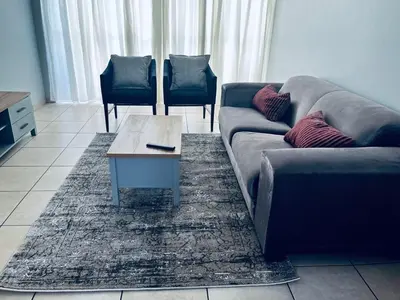 a living room with a couch and a coffee table at Stylish 1 Bed Self Catering Near OR Tambo in Kempton Park