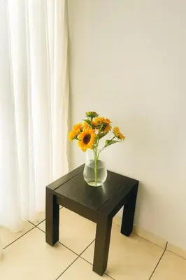 a vase of flowers sitting on a black table at Stylish 1 Bed Self Catering Near OR Tambo in Kempton Park