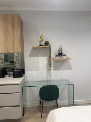 a glass table with a chair in a room at 4413 At Ellipse Waterfall in Midrand