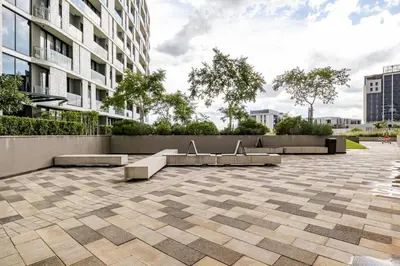 a courtyard in a city with benches and a building at 4413 At Ellipse Waterfall in Midrand