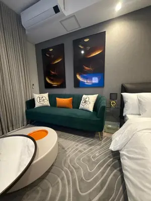 a living room with a green couch and a bed at 4413 At Ellipse Waterfall in Midrand