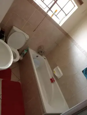 a bathroom with a tub and a toilet and a sink at Fairway Gardens in Pretoria