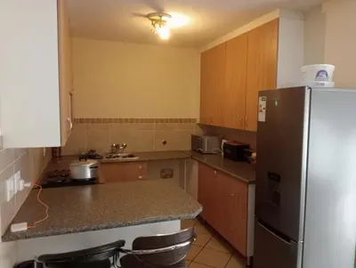 a kitchen with a refrigerator and a counter top at Fairway Gardens in Pretoria
