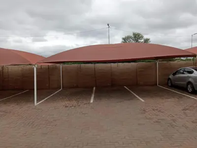 two large red umbrellas in a parking lot at Fairway Gardens in Pretoria