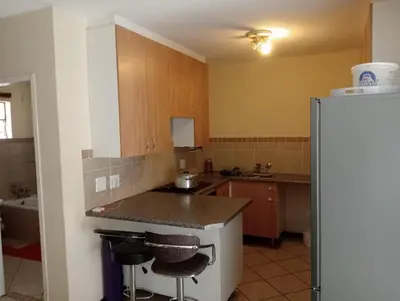 a kitchen with a counter and a refrigerator at Fairway Gardens in Pretoria