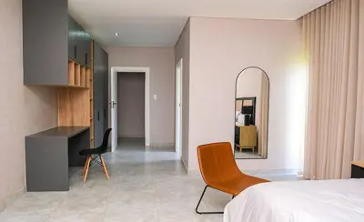 a bedroom with a bed and a mirror and a chair at Mupauli Boutique Lodge