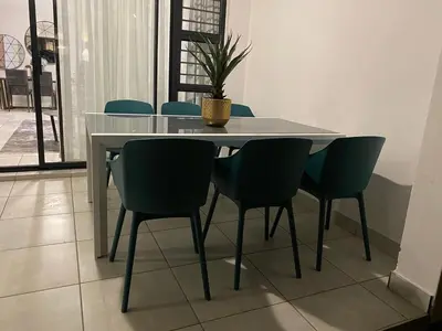 a white table with chairs and a potted plant on it at Unit 438, The Blyde, Pretoria East in Pretoria