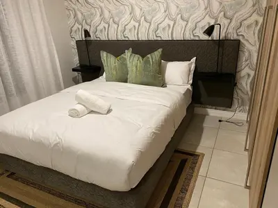 a bedroom with a bed with a roll on it at Unit 438, The Blyde, Pretoria East in Pretoria