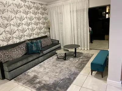 a living room with a couch and a table at Unit 438, The Blyde, Pretoria East in Pretoria