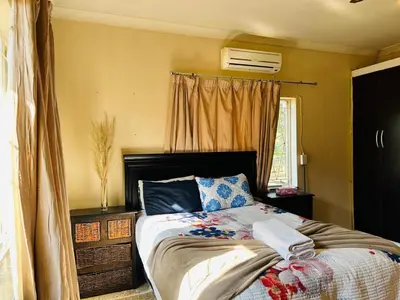 a bedroom with a bed and a window at Bird & Bed Farmhouse in Brits