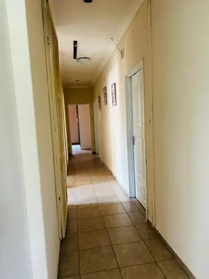 an empty hallway with a door and a tile floor at Bird & Bed Farmhouse in Brits