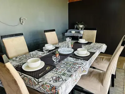 a dining room table with a table cloth on it at Bird & Bed Farmhouse in Brits