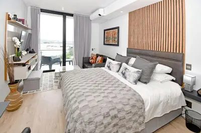 a bedroom with a large bed and a couch at Stylish Penthouse Studio in Ellipse Waterfall in Midrand
