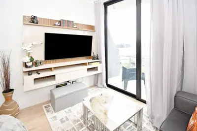 a living room with a tv on a wall at Stylish Penthouse Studio in Ellipse Waterfall in Midrand