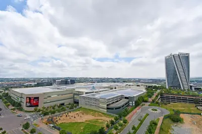 an aerial view of a city with a tall building at Stylish Penthouse Studio in Ellipse Waterfall in Midrand