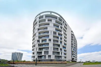a tall white building with a round top at Stylish Penthouse Studio in Ellipse Waterfall in Midrand