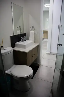 a bathroom with a toilet and a sink and a mirror at Maude Retreats in Midrand