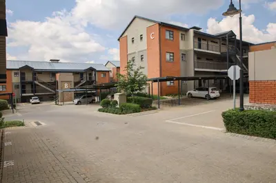 an empty parking lot in front of a building at Maude Retreats in Midrand