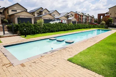 a swimming pool in a yard with houses at Maude Retreats in Midrand