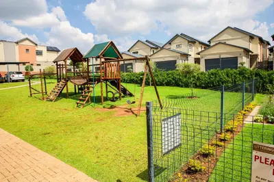 a playground with a swing set in a yard at Maude Retreats in Midrand