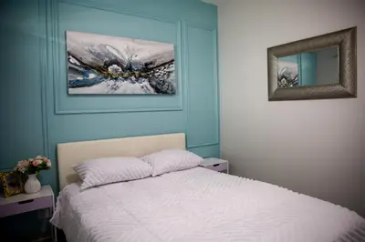 a bedroom with a bed and a painting on the wall at Maude Retreats in Midrand