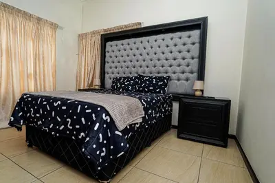 a bedroom with a bed with a large headboard at Royal Palm in Mokopane