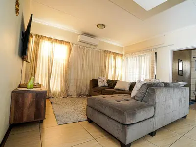 a living room with a couch and a tv in it at Royal Palm in Mokopane