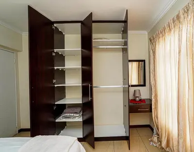 a large wooden book shelf in a bedroom at Royal Palm in Mokopane