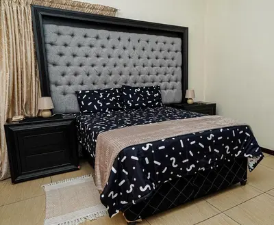 a bedroom with a bed with a large headboard at Royal Palm in Mokopane