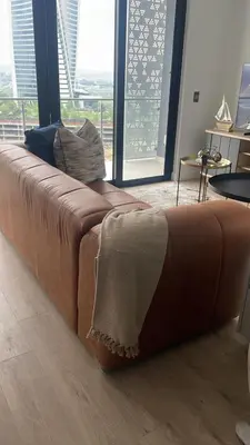 a brown couch in a room with a large window at Ellipse Waterfall 41110 in Midrand